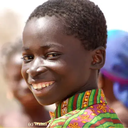 Man sieht einen Jungen, der in die Kamera lächelt.