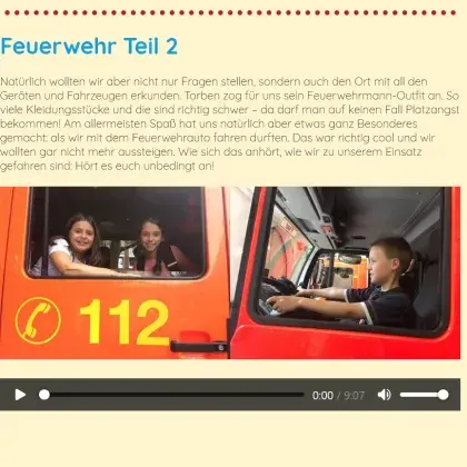 Man sieht Kinder in einem Feuerwehrauto.