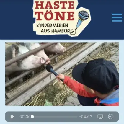Ein Kinderreporter hält einem Schwein das Mikrofon hin